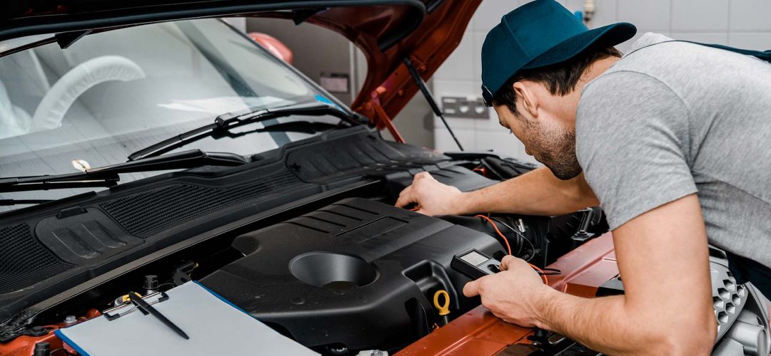 auto-mechanic-with-multimeter-voltmeter-checking-c-7MTRPJF.jpg